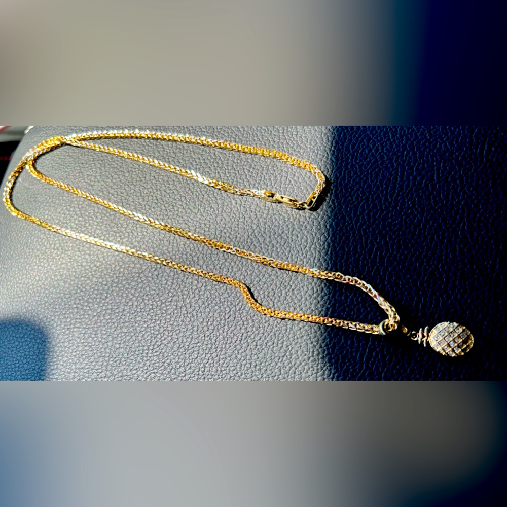 gold necklace with diamond pineapple pendant.